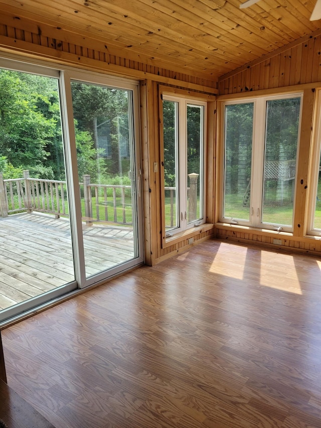 4085 N Cedar Lake Rd, Edmore, MI 48829 - unfurnished sunroom featuring healthy amount of natural light, lofted ceiling, wood finished floors, wooden walls, and a deck