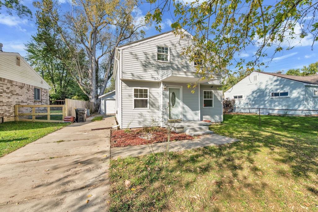 view of front of property with a front yard, an outbuilding, and a garage