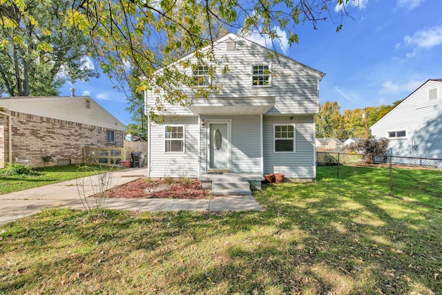 rear view of property featuring a lawn