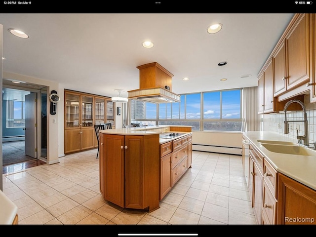 kitchen featuring sink, a center island, a baseboard radiator, backsplash, and light tile patterned floors