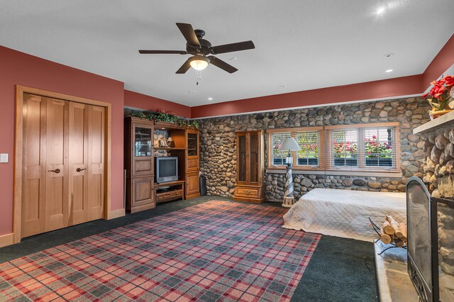 unfurnished bedroom featuring baseboards, dark colored carpet, and a ceiling fan