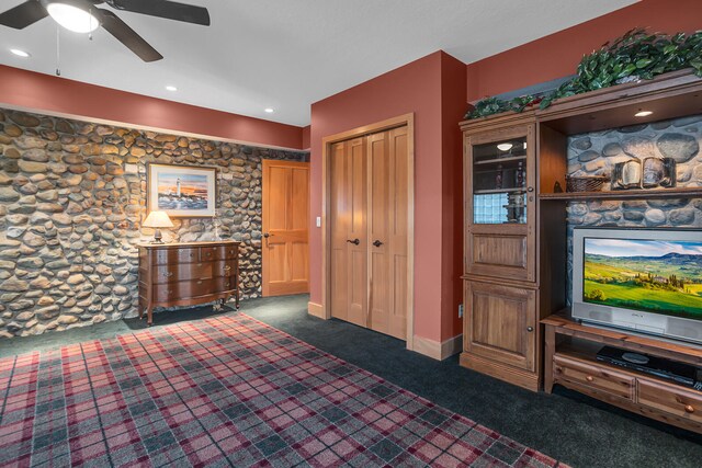 bedroom featuring a ceiling fan, dark carpet, and a closet