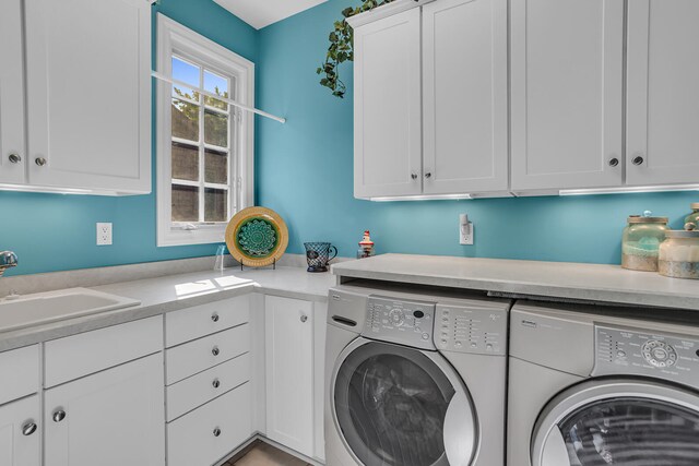 laundry room featuring washer and clothes dryer, a sink, and cabinet space