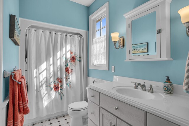 full bathroom featuring shower / tub combo with curtain, vanity, toilet, and tile patterned floors