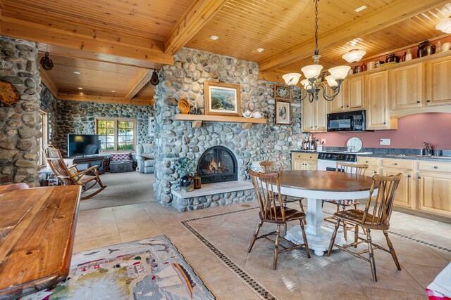 kitchen featuring dark countertops, hanging light fixtures, a sink, a stone fireplace, and black microwave