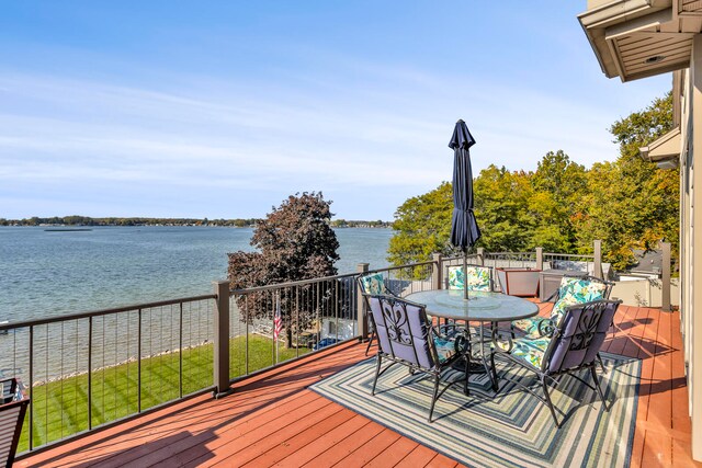 wooden deck featuring a water view and outdoor dining space