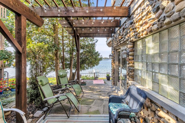 view of patio / terrace featuring a water view, fence, and a pergola