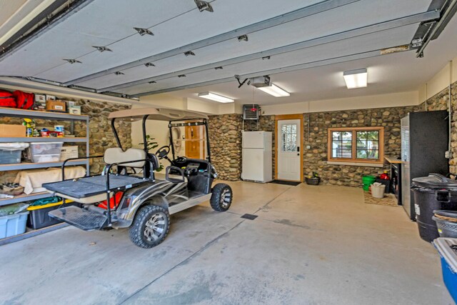 garage with freestanding refrigerator and a garage door opener