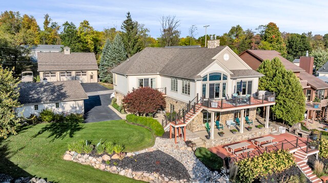 back of house featuring a lawn, a chimney, stairway, a deck, and a patio area