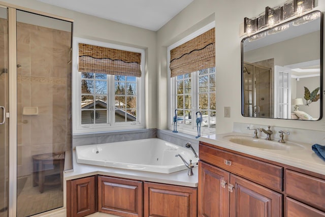 bathroom with a shower stall, a bath, and vanity