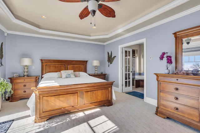 bedroom featuring light carpet, a tray ceiling, crown molding, and baseboards