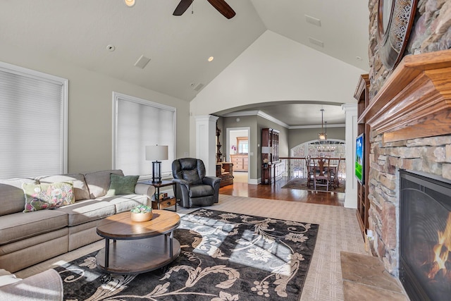 living area with arched walkways, dark wood-style flooring, a fireplace, high vaulted ceiling, and ceiling fan with notable chandelier