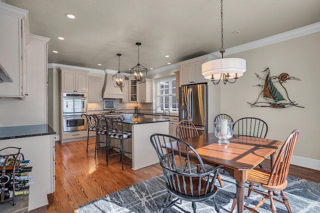 dining space with light wood-style floors, recessed lighting, and ornamental molding