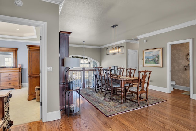 dining room featuring a chandelier, crown molding, and wood finished floors