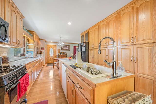 21598 Sylvan Rd, Reed City, MI 49677 - kitchen with black appliances, a sink, light wood-style floors, recessed lighting, and glass insert cabinets