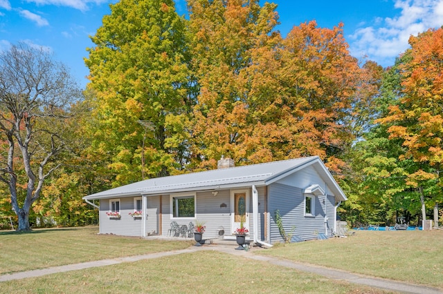 21598 Sylvan Rd, Reed City, MI 49677 - view of front of property featuring a chimney, a front yard, and metal roof