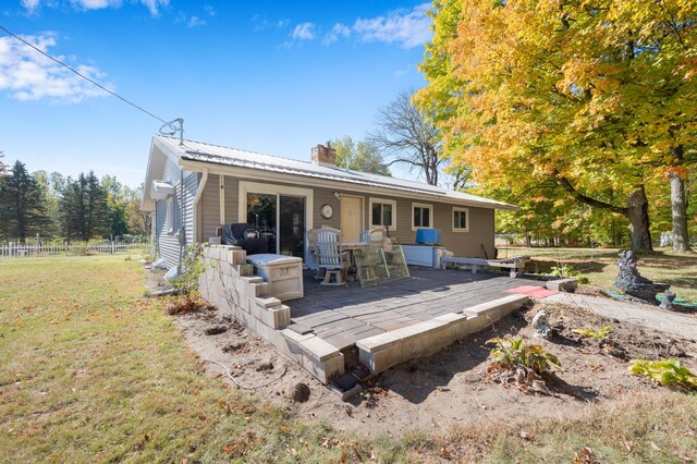 21598 Sylvan Rd, Reed City, MI 49677 - rear view of property with a deck, metal roof, and a chimney