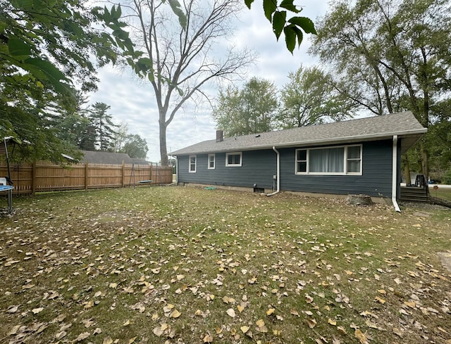 back of house with a trampoline