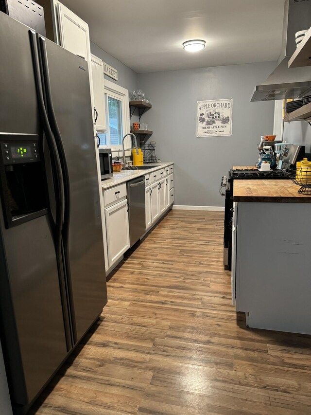 13067 Red Arrow Hwy, Sawyer, MI 49125 - kitchen featuring stainless steel appliances, open shelves, wall chimney range hood, a sink, and white cabinets