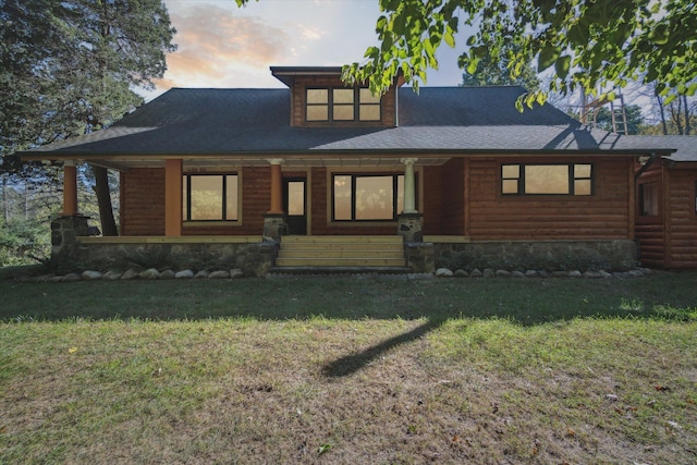 view of front of property with covered porch and a yard