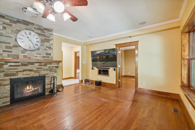 unfurnished living room featuring hardwood / wood-style flooring, a fireplace, ceiling fan, and crown molding