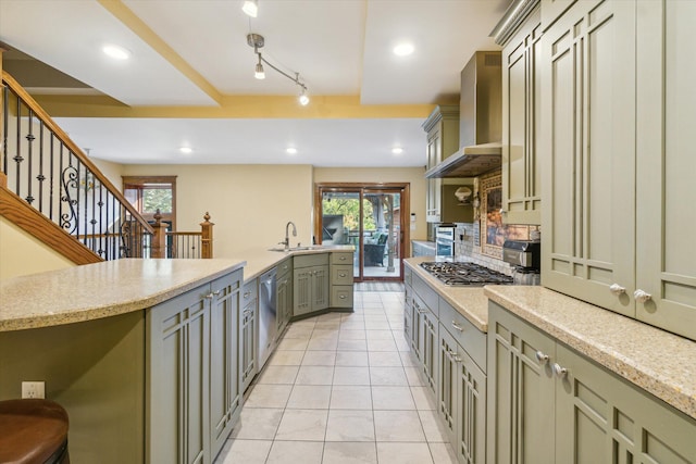 kitchen featuring appliances with stainless steel finishes, sink, a wealth of natural light, and wall chimney range hood