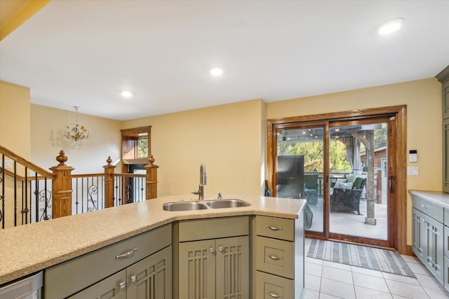 kitchen with gray cabinets, light tile patterned floors, sink, and an inviting chandelier