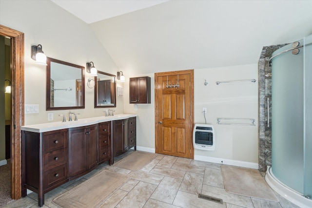 bathroom with vanity, lofted ceiling, walk in shower, and heating unit