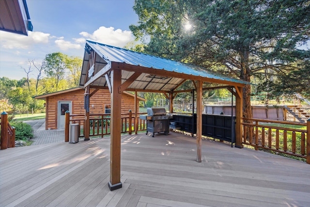 wooden terrace with a gazebo and area for grilling