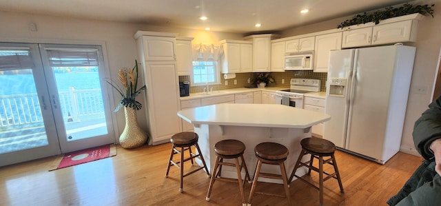 5578 Lake Shore Dr, Weidman, MI 48893 - kitchen featuring white appliances, a sink, white cabinets, french doors, and decorative backsplash