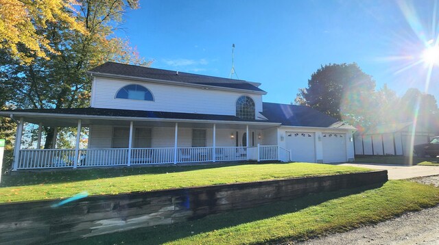 5578 Lake Shore Dr, Weidman, MI 48893 - farmhouse inspired home with concrete driveway, covered porch, an attached garage, and a front yard