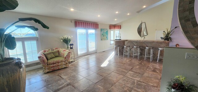 5578 Lake Shore Dr, Weidman, MI 48893 - living room with healthy amount of natural light, recessed lighting, bar area, vaulted ceiling, and baseboards