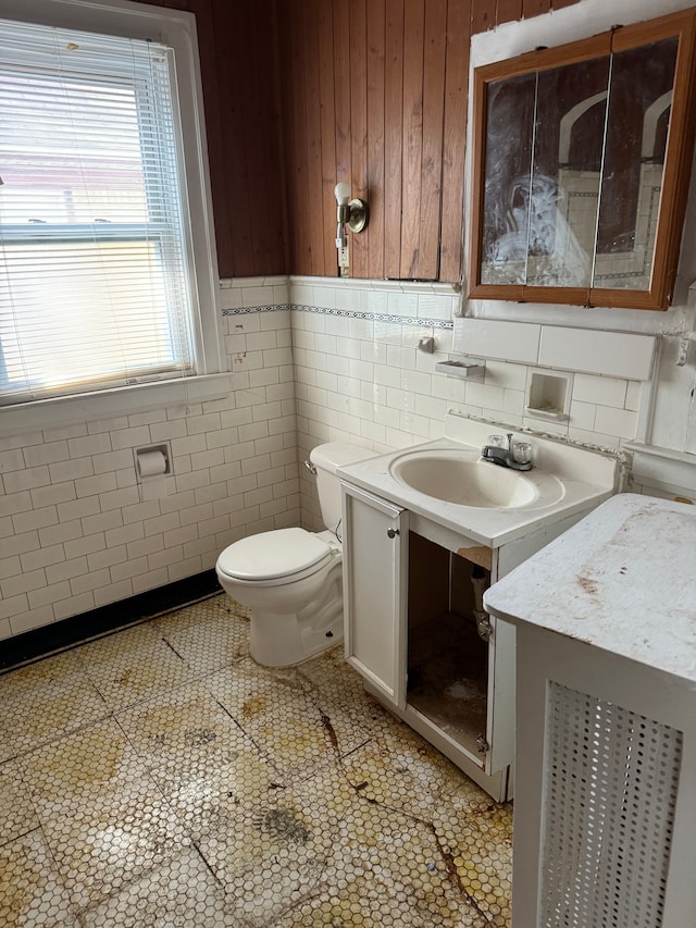 bathroom with tile patterned flooring, vanity, tile walls, and toilet