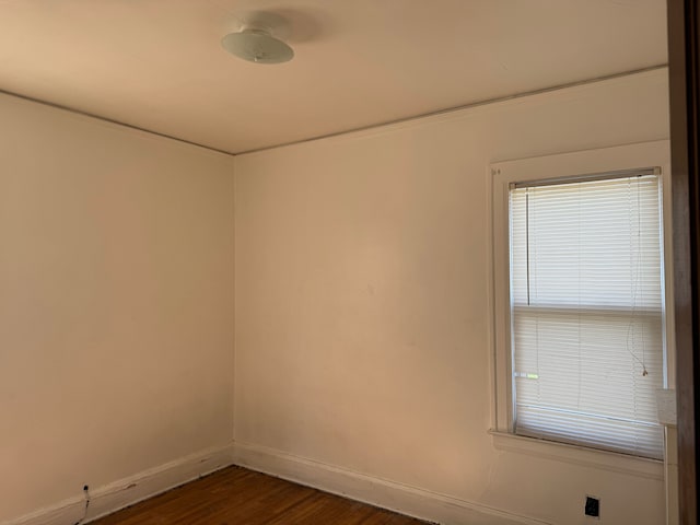 empty room with dark hardwood / wood-style flooring