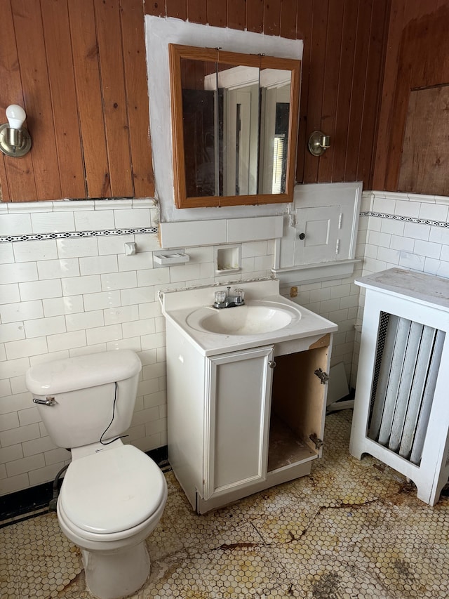 bathroom with tile patterned floors, vanity, tile walls, and toilet