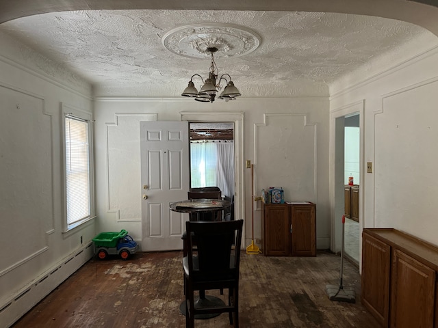 dining space with a textured ceiling, dark hardwood / wood-style floors, an inviting chandelier, and baseboard heating