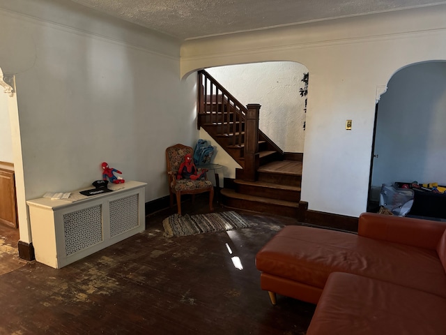 living room featuring dark wood-type flooring and a textured ceiling