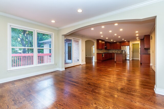 4345 Pine Tree Trl, Bloomfield Hills, MI 48302 - unfurnished living room with arched walkways, dark wood-type flooring, crown molding, recessed lighting, and baseboards
