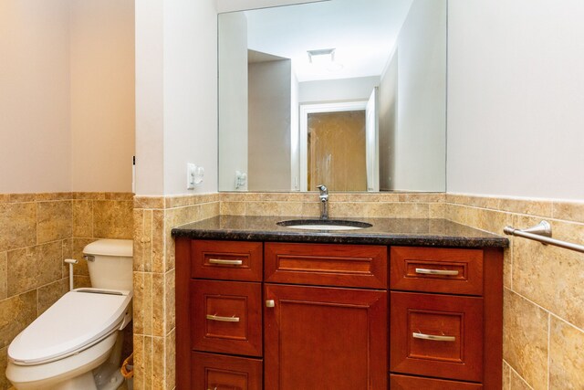 4345 Pine Tree Trl, Bloomfield Hills, MI 48302 - bathroom featuring tile walls, vanity, wainscoting, and toilet