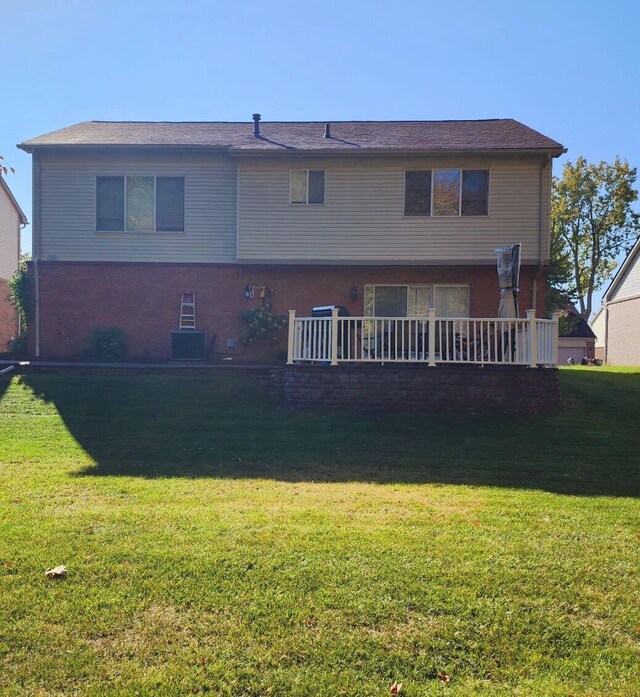 back of house featuring central AC and a yard