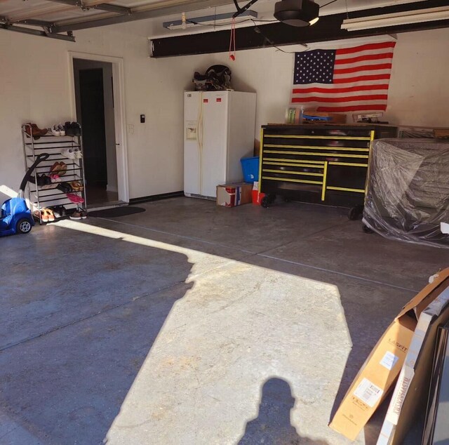 garage featuring white fridge with ice dispenser