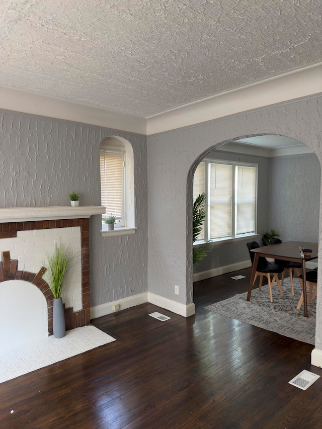 interior space featuring a textured ceiling, dark hardwood / wood-style floors, and plenty of natural light