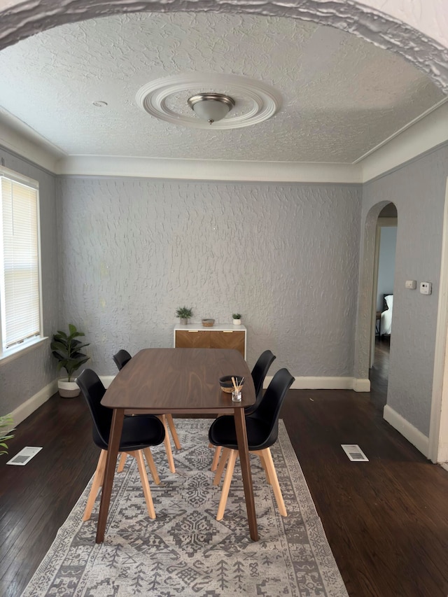 dining area featuring dark hardwood / wood-style flooring and a textured ceiling