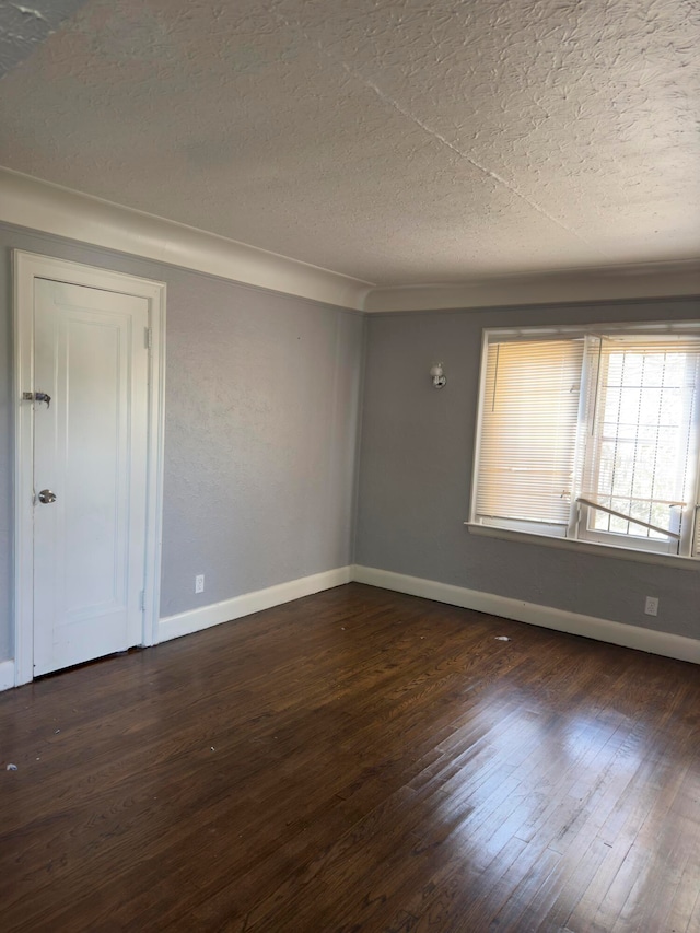 empty room featuring dark hardwood / wood-style flooring and a textured ceiling