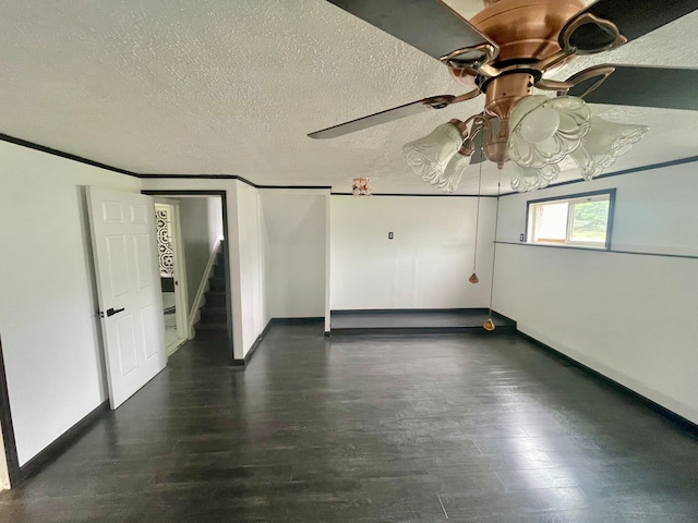 unfurnished room featuring a textured ceiling, ceiling fan, and dark wood-type flooring