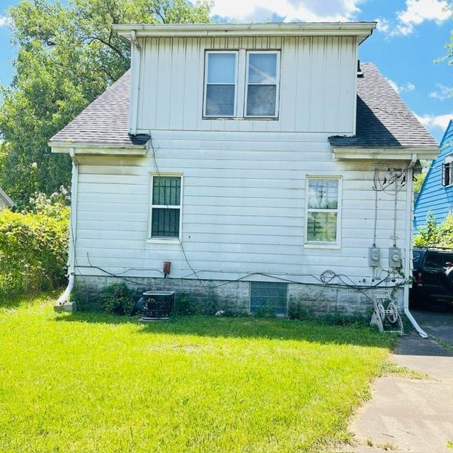 view of side of home featuring a yard and cooling unit