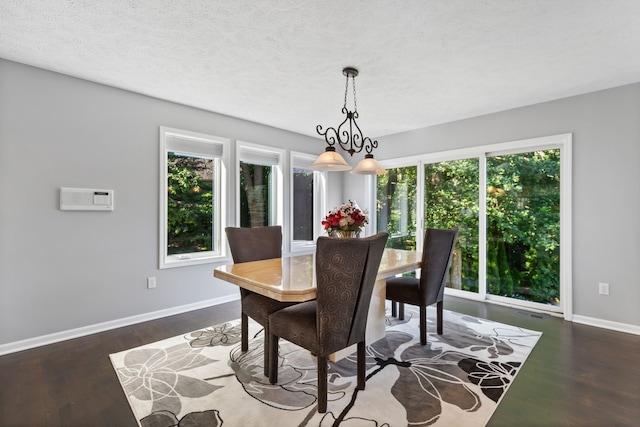 dining room featuring a notable chandelier, dark wood-type flooring, and a wealth of natural light