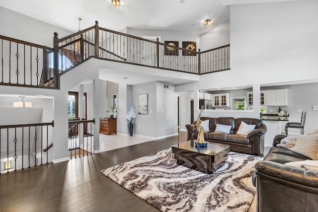 living room with hardwood / wood-style floors and high vaulted ceiling