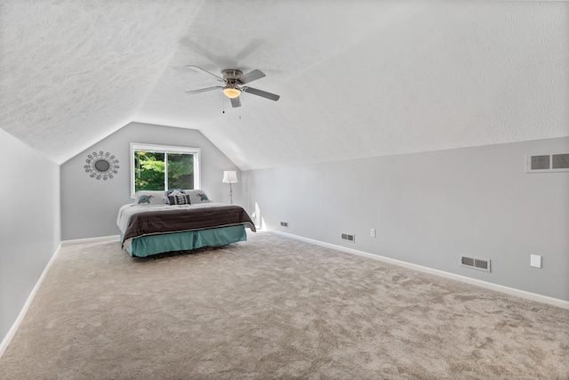 unfurnished bedroom with carpet flooring, a textured ceiling, ceiling fan, and lofted ceiling