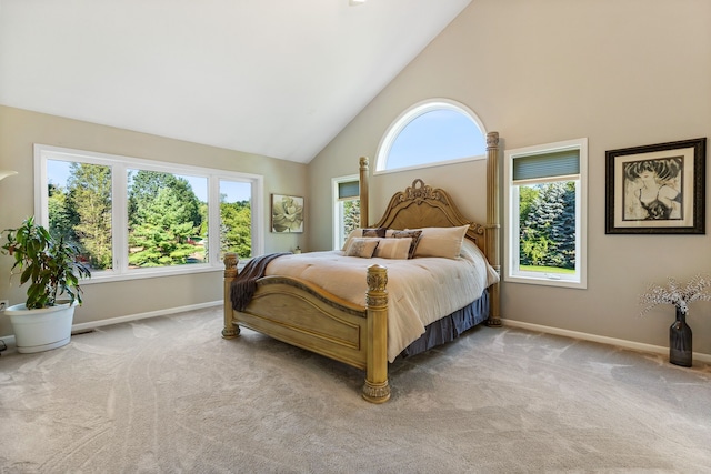 carpeted bedroom featuring high vaulted ceiling and multiple windows